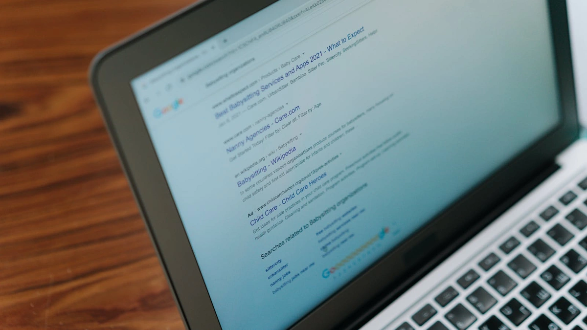laptop showing a Google search results page on a wooden desk