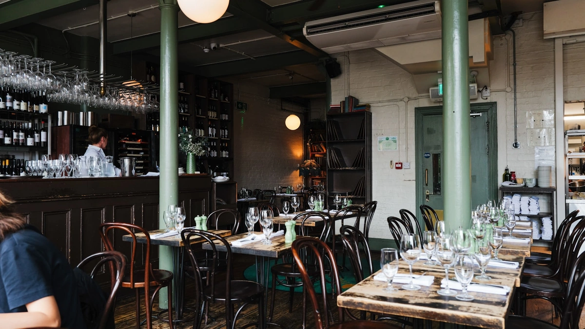 Restaurant interior with bar and dining tables set for service