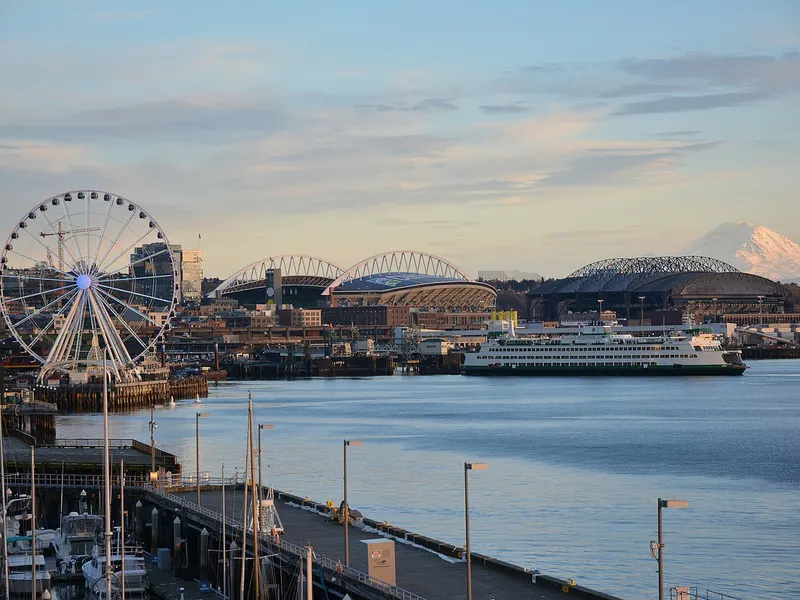 The Seattle waterfront with the Great Wheel, a ferry and Mount Rainier.
